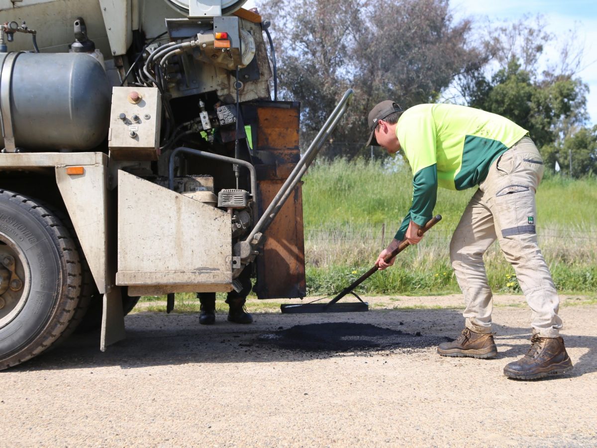 Civil works crew fix potholes in road