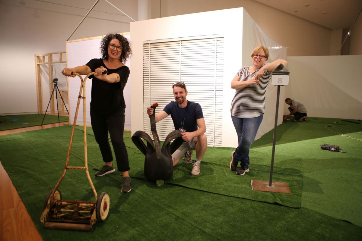 Two women and a man standing in front of an art installation