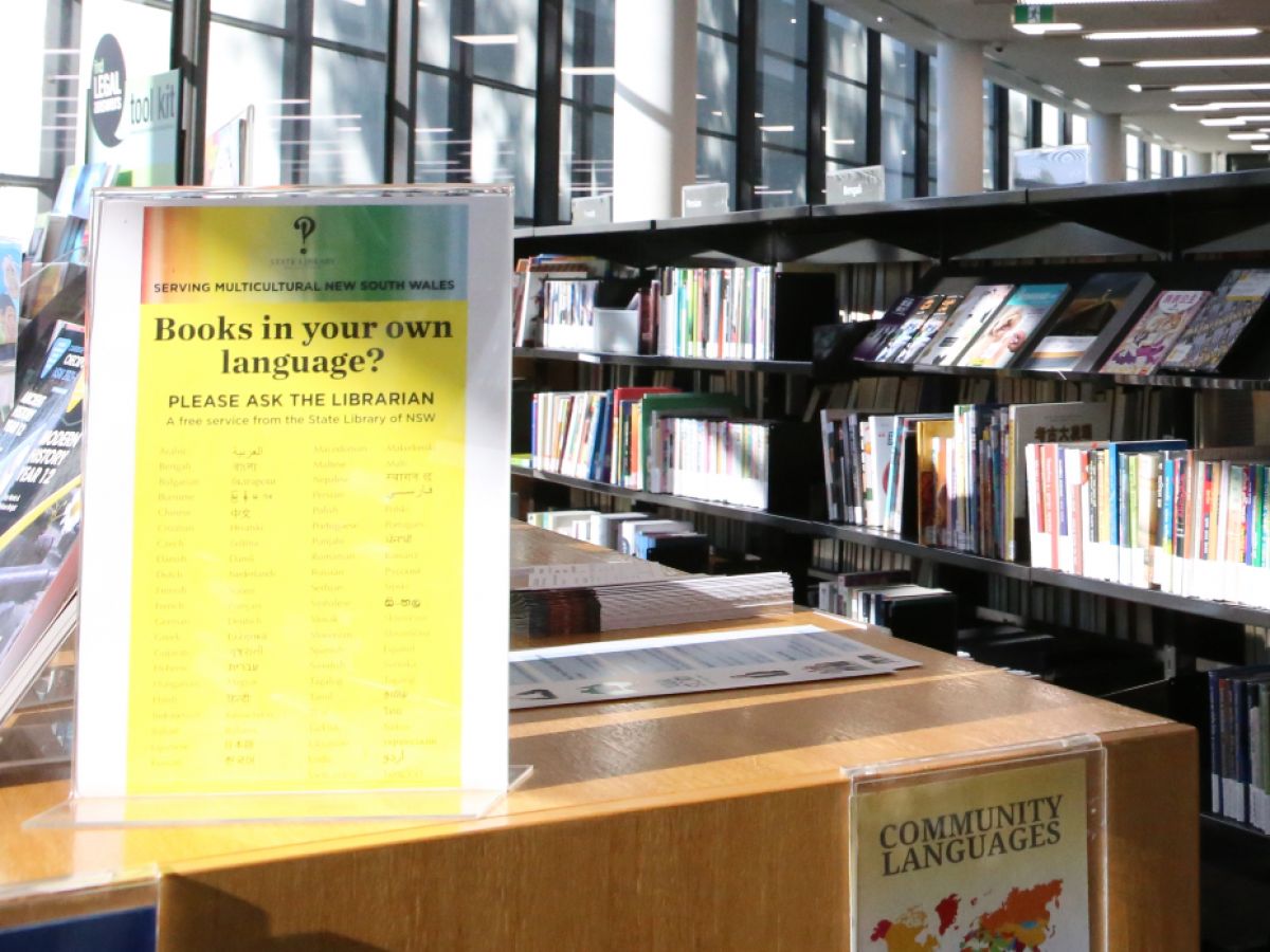 Sign on top of book shelving at library