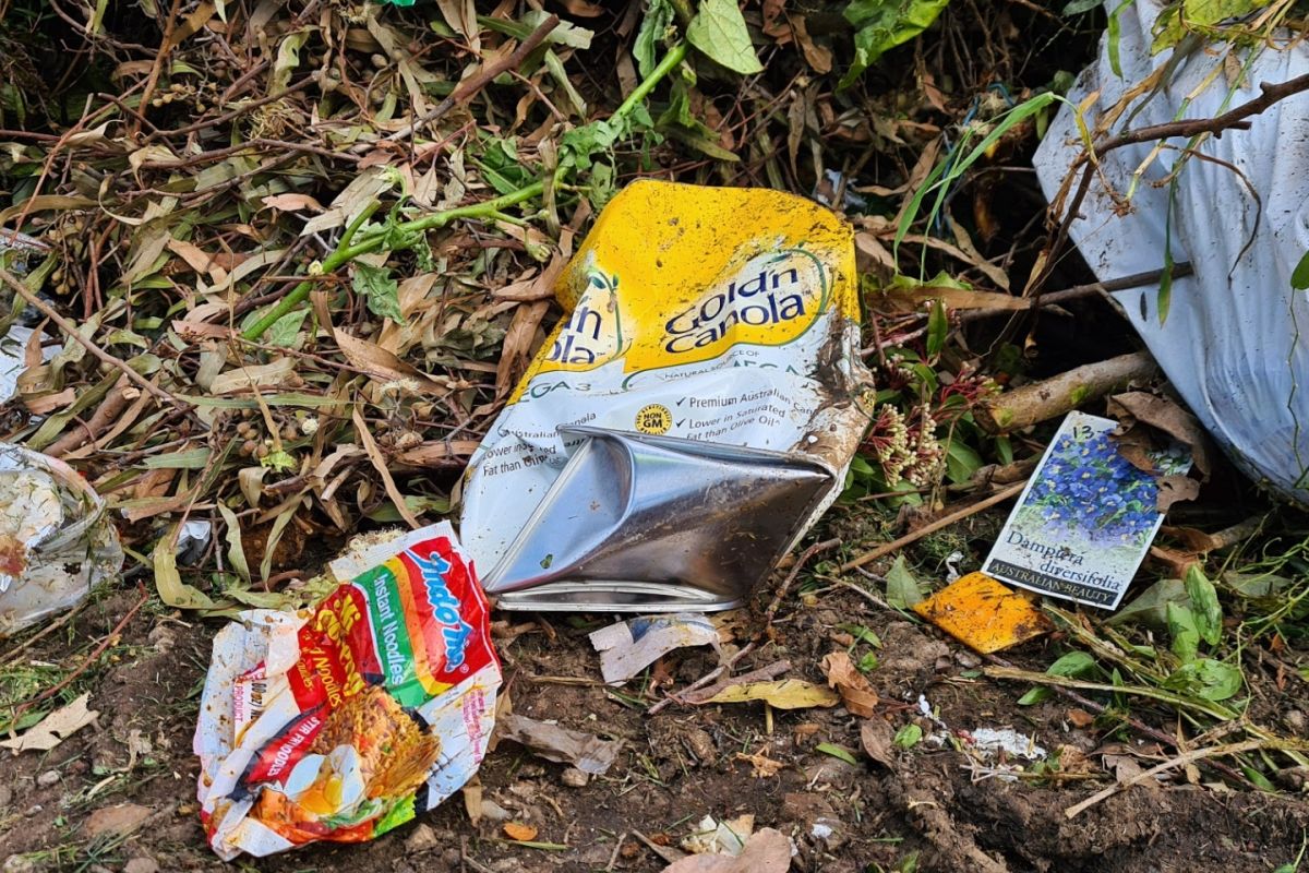 metal canola container dumped with FOGO waste