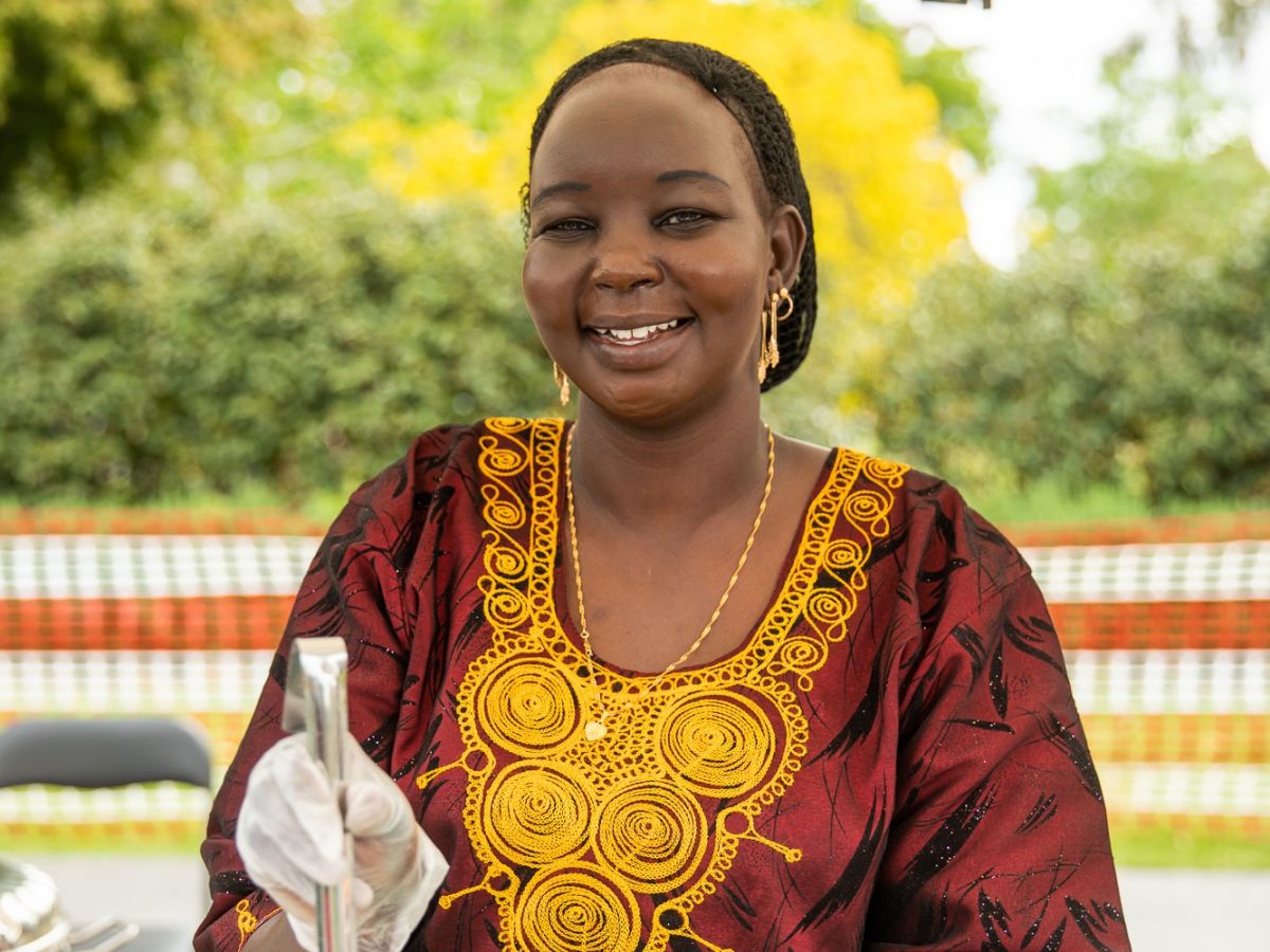 Woman in tradition African dress serving food at stall