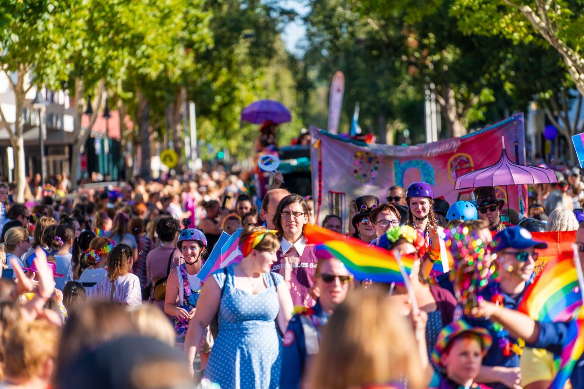 March along street with people in colourful outfits