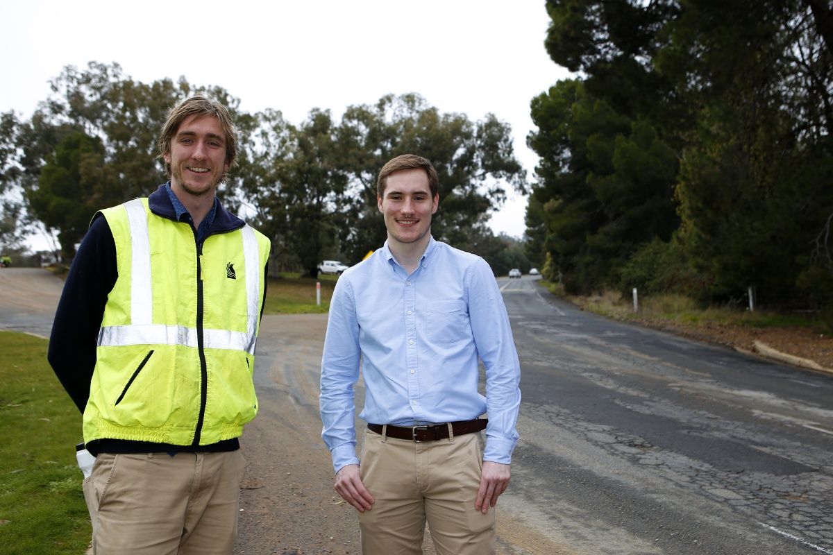 Two men standing beside Lord Baden Powell Drive