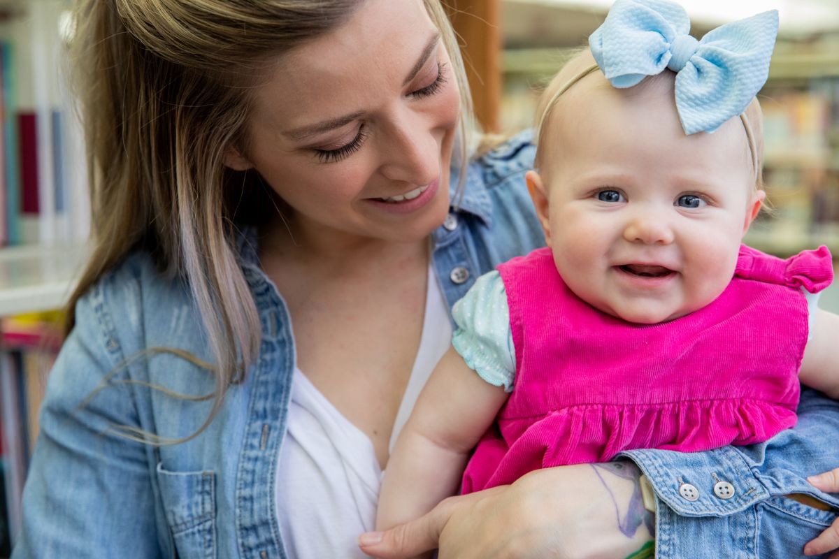 A woman smiles at her happy baby.