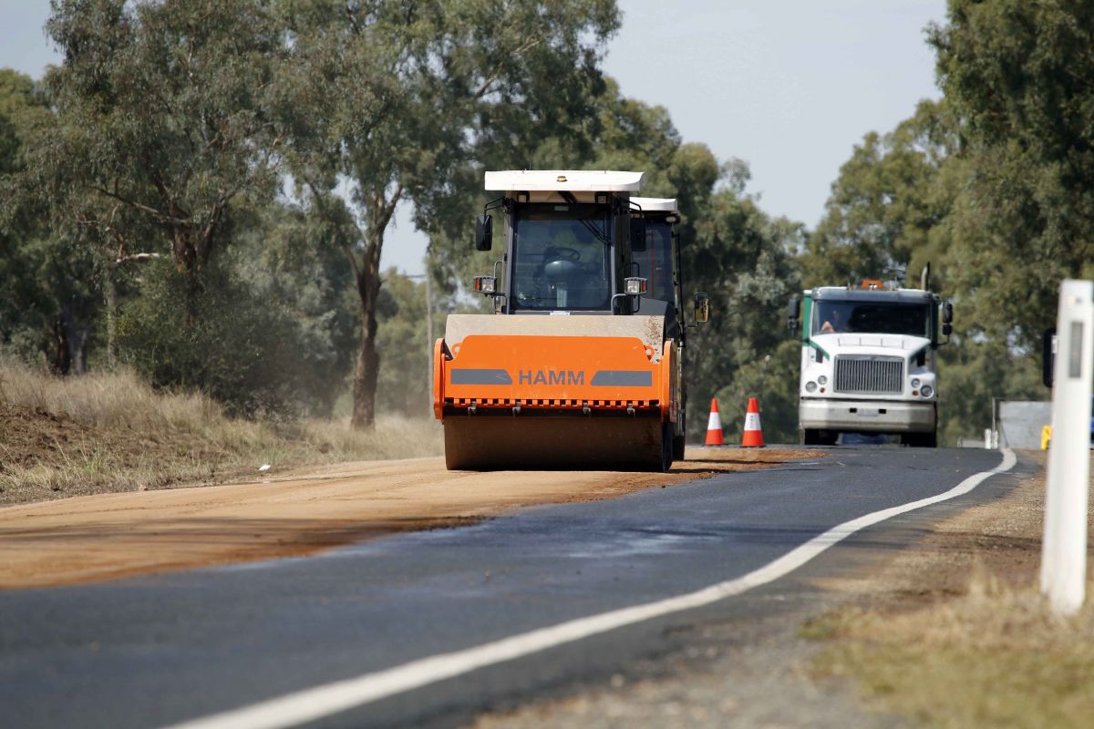 Roller compacting pavement base on heavy patching works