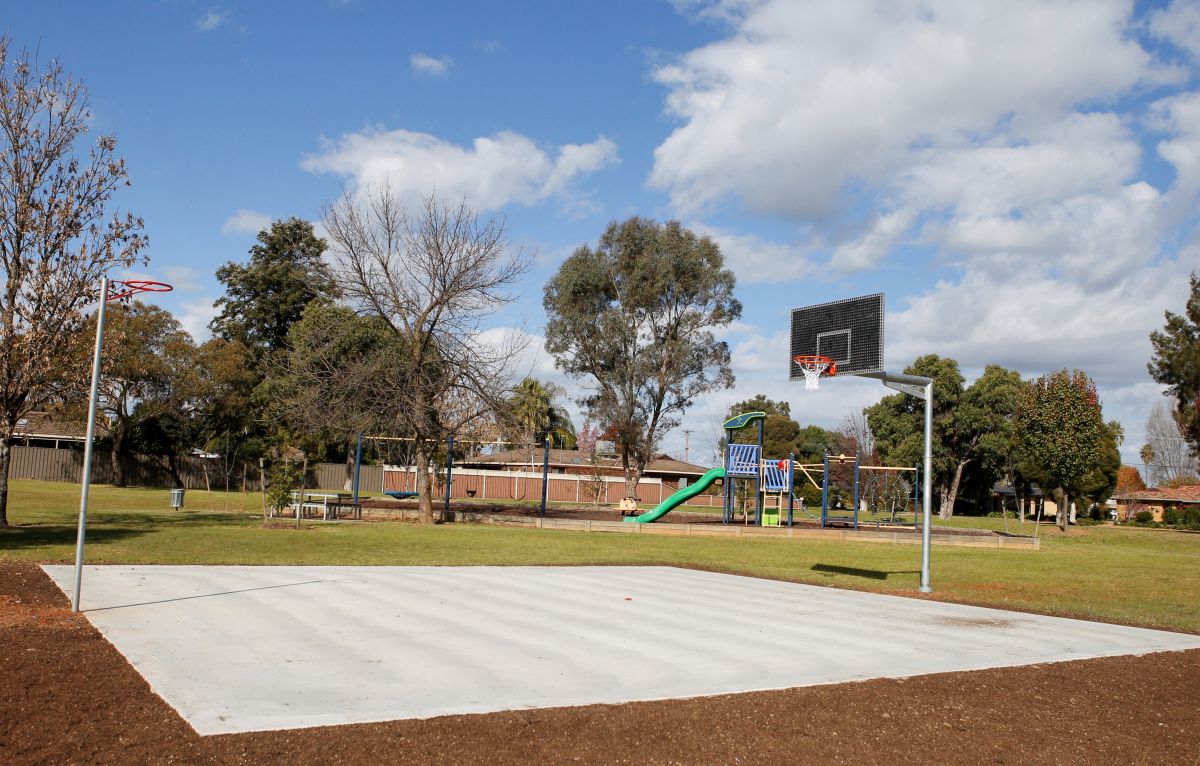 A half-basketball court in a park. 