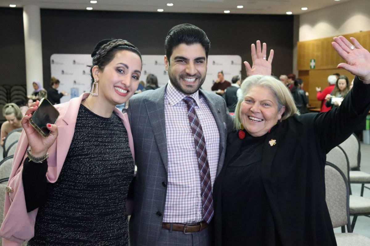 Keynote speaker Tariq Kareemi and partner Shahri Rafi with Wiradyuri Elder Aunty Mary Atkinson smiling and waving at camera. 