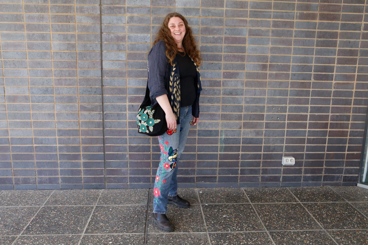 a woman wearing clothing with embroidery all over it. 