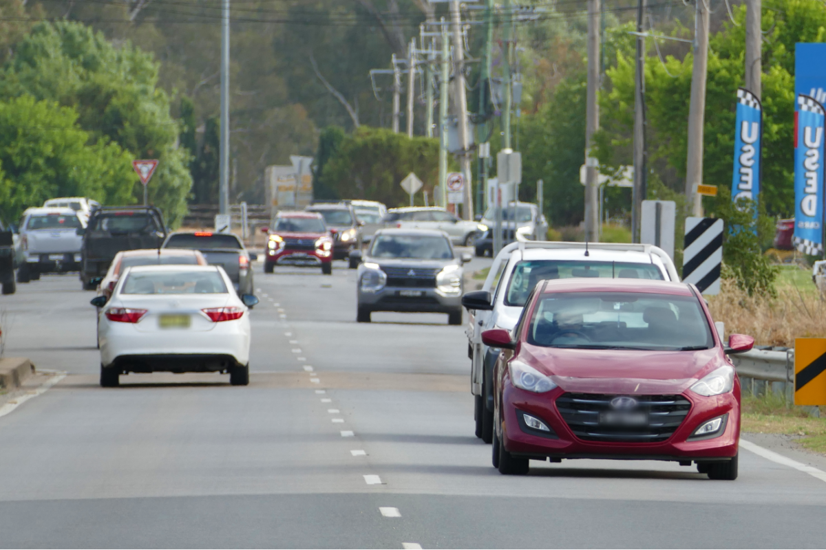 Cars on road crossing a small concrete bridge