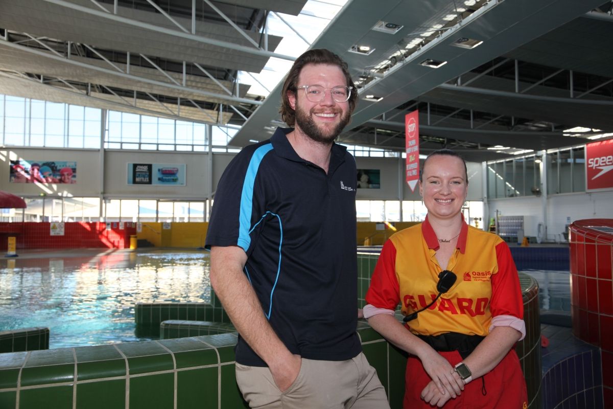 Oasis Program Manager Brad Ingram and lifeguard Chelsea Girdler standing in front of pools at Oasis Aquatic Centre