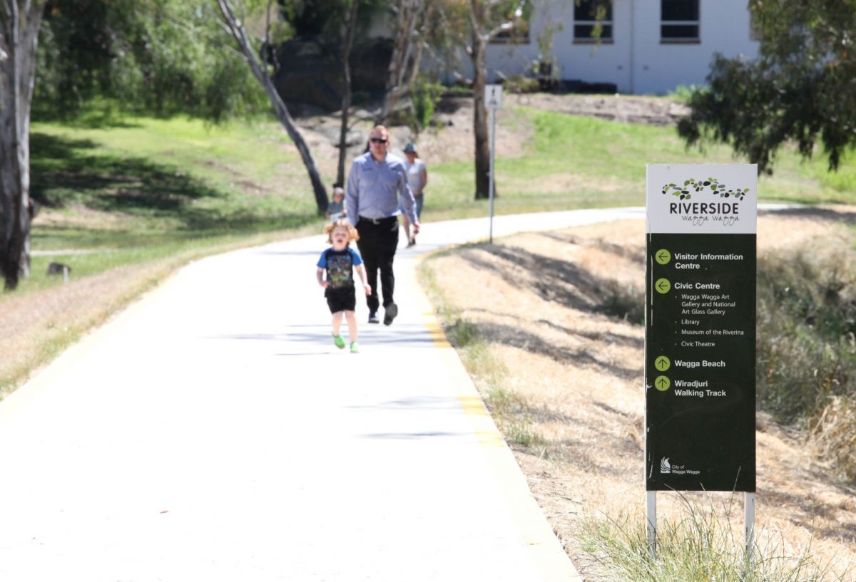 Dad and kid walk along path