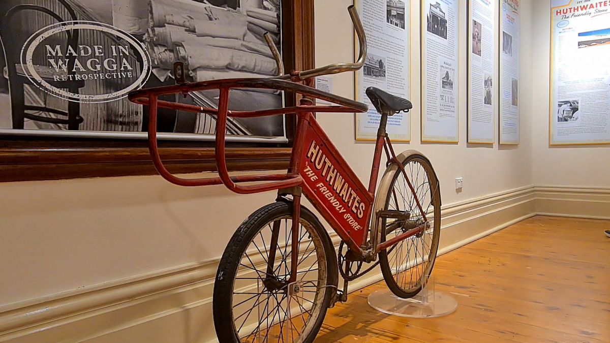 Old delivery bike, wall hangings at museum exhibition