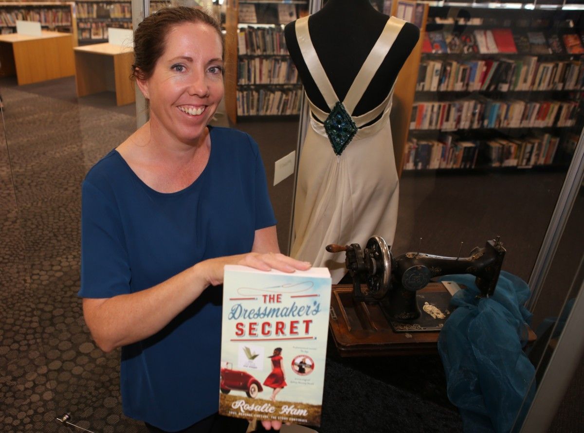 woman holding book in front of dress on display