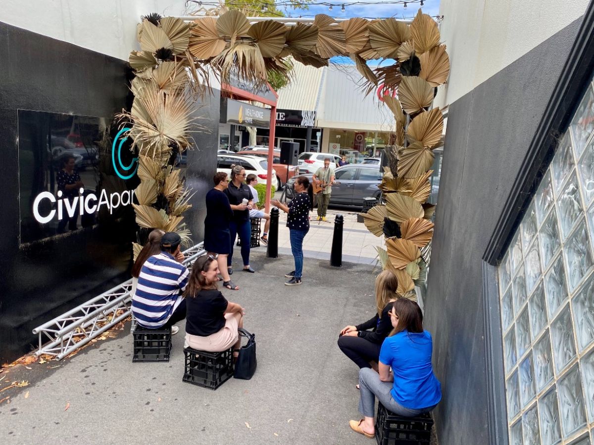 Group of people listening to musician in laneway