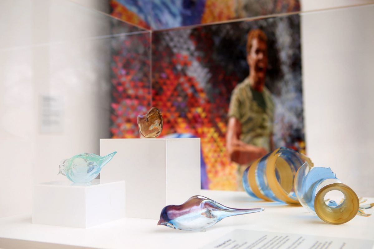 Glass birds in cabinet with quilt in background