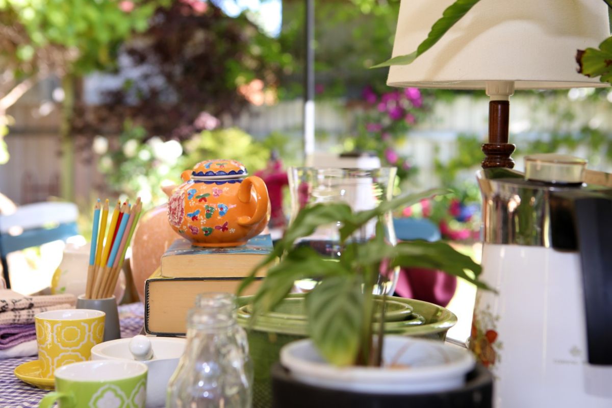 tea pot, glasses, plant, lamp and other household items on table