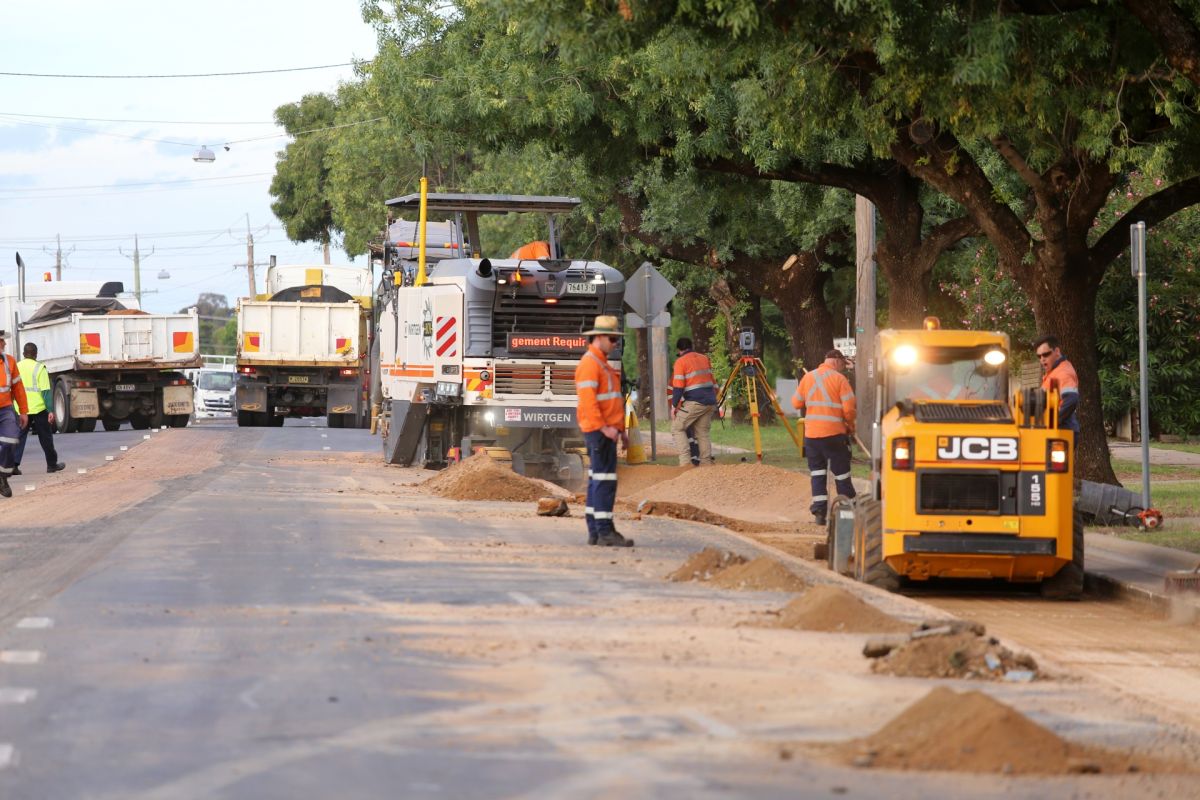 Work crews and equipment milling out road