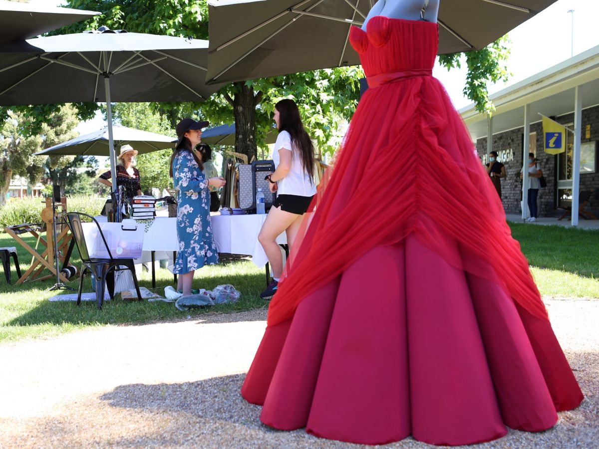 Red dress in foreground with market stalls in background