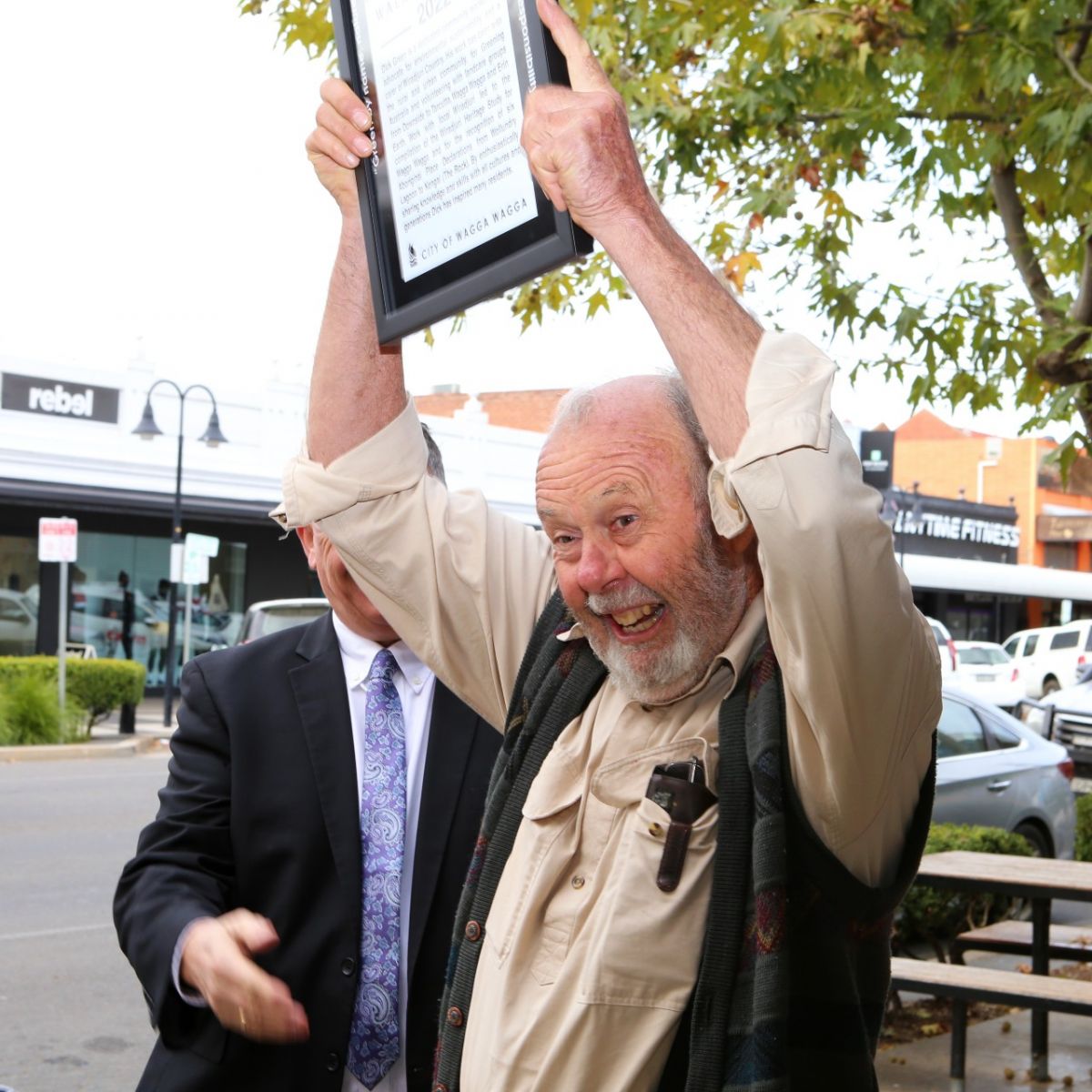 Dick Green holding walk of honour framed photo in air