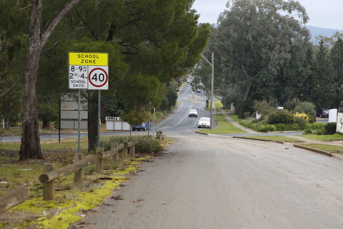 Road with school zone sign in foreground