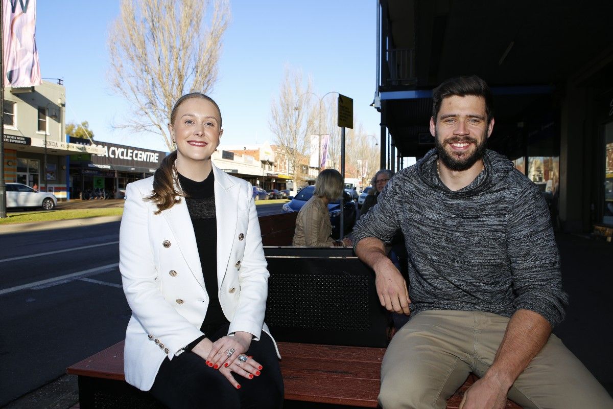 Woman and man sitting on new parklet seating with people in background