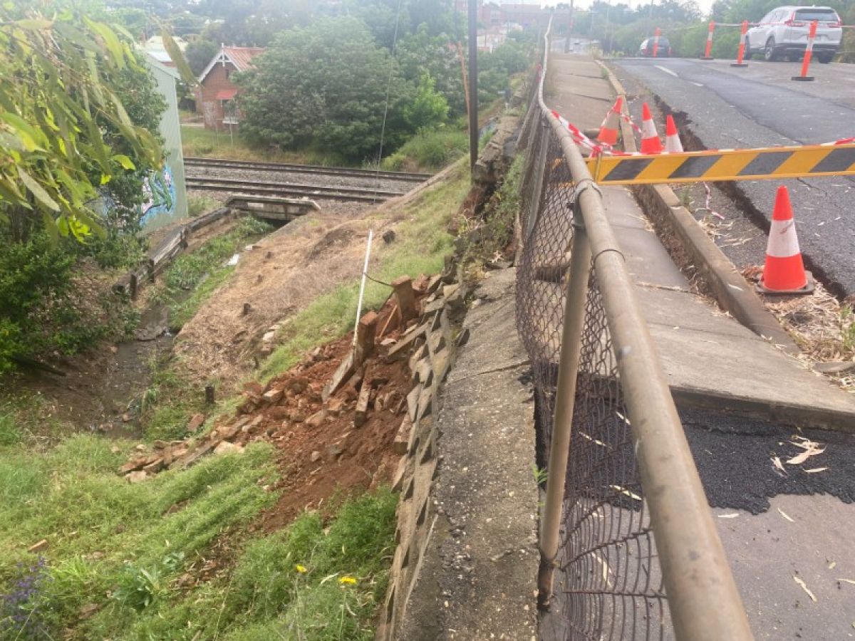 A retaining wall has given way beneath a road