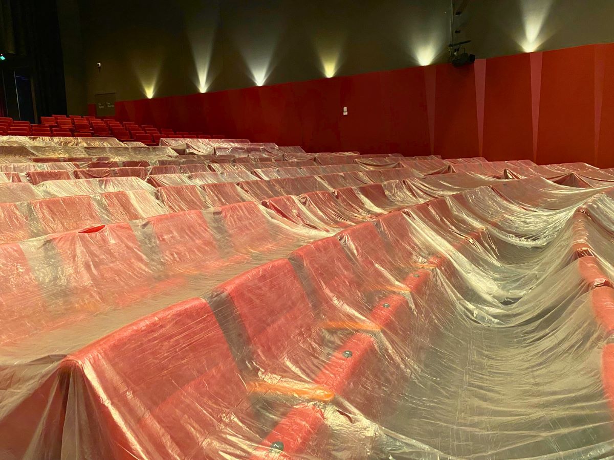 Rows of read seats are covered in clear plastic wrap.