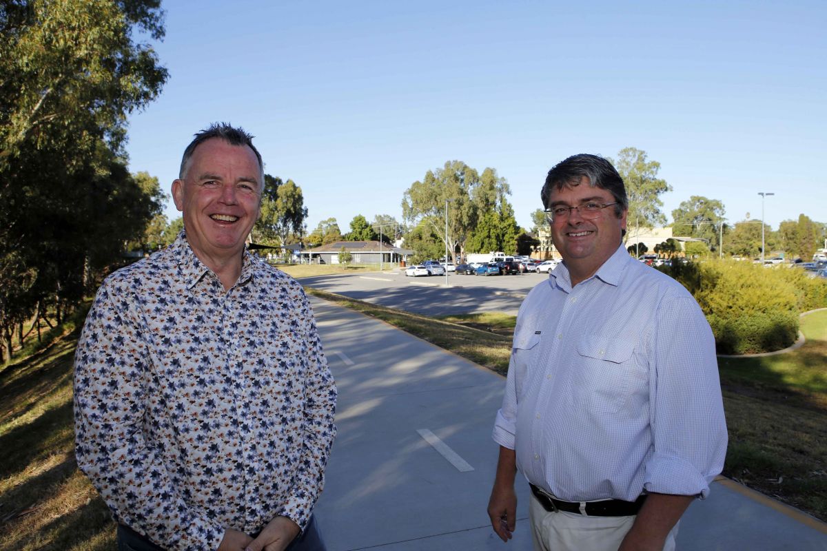 Mayor and General Manager on levee shared path with visitor information centre in background