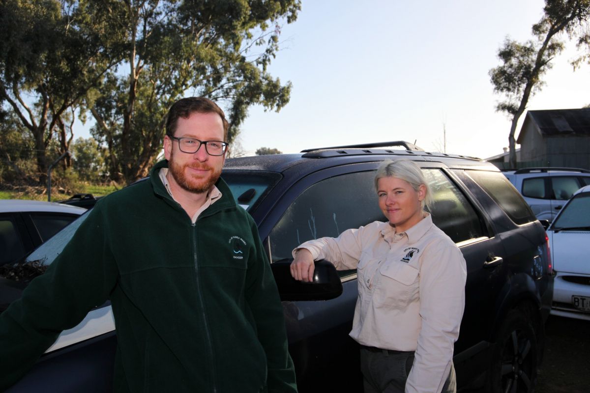 Ranges standing beside vehicle in impound lot