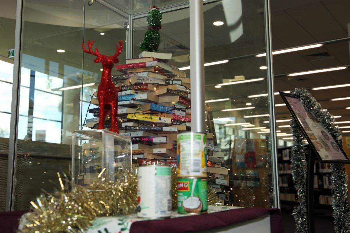 Christmas tree made out of books, inside glass cabinet