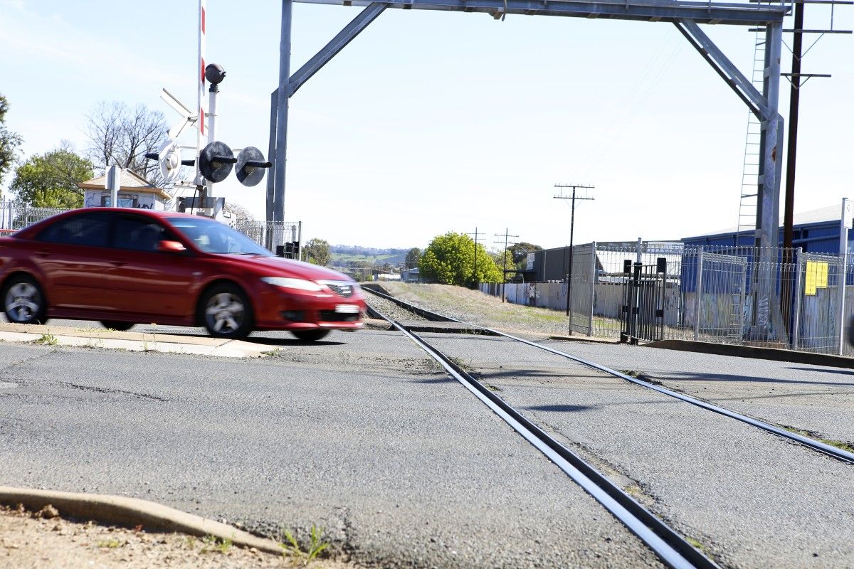 Car about to cross railway line at controlled crossing