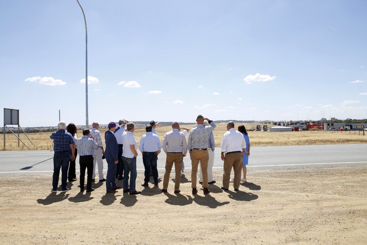 Group of men and women standing in group, looking at development site.