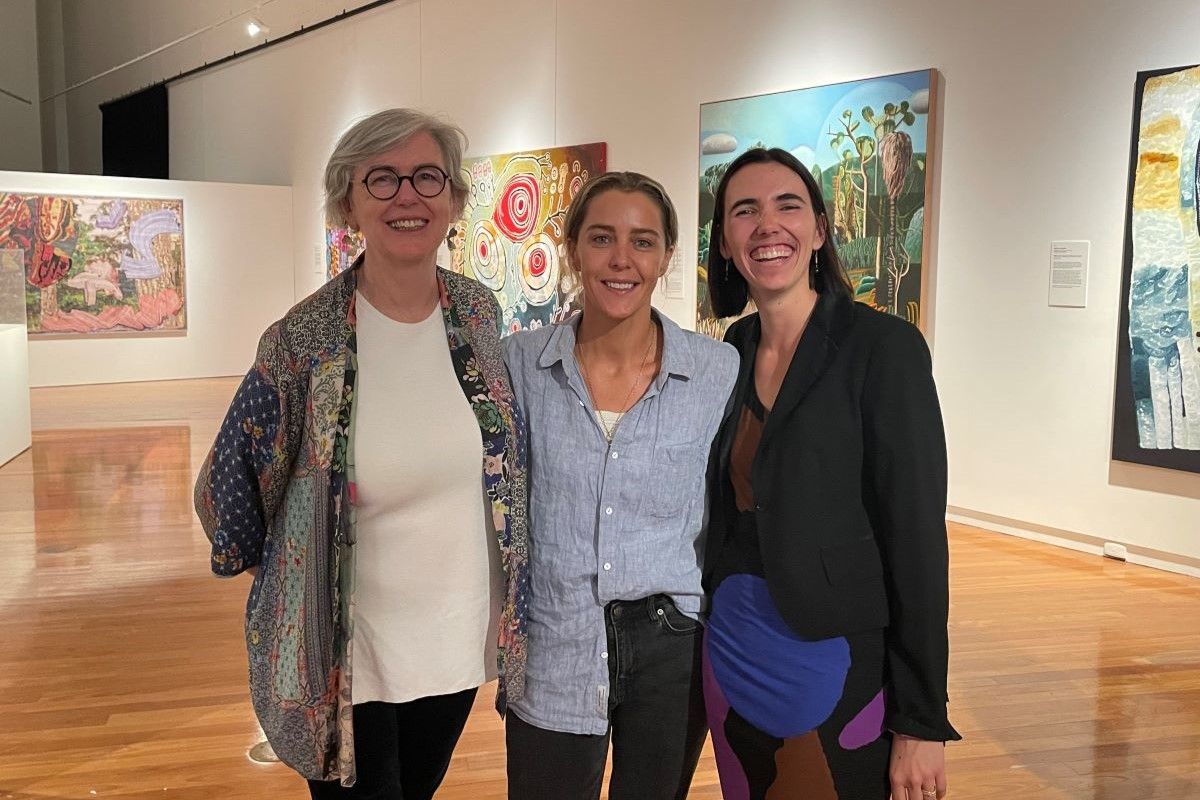 Three women in an art gallery space.