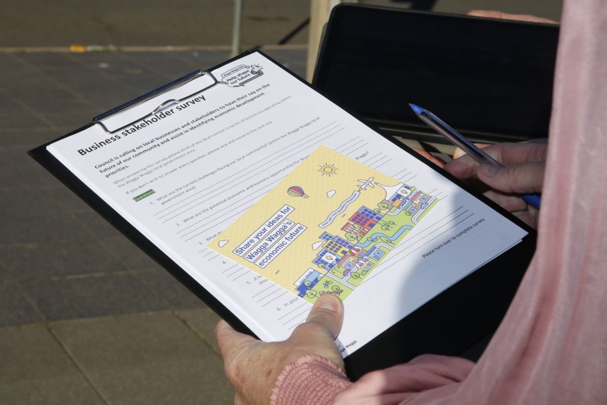 Hands holding a printed survey on a clipboard.