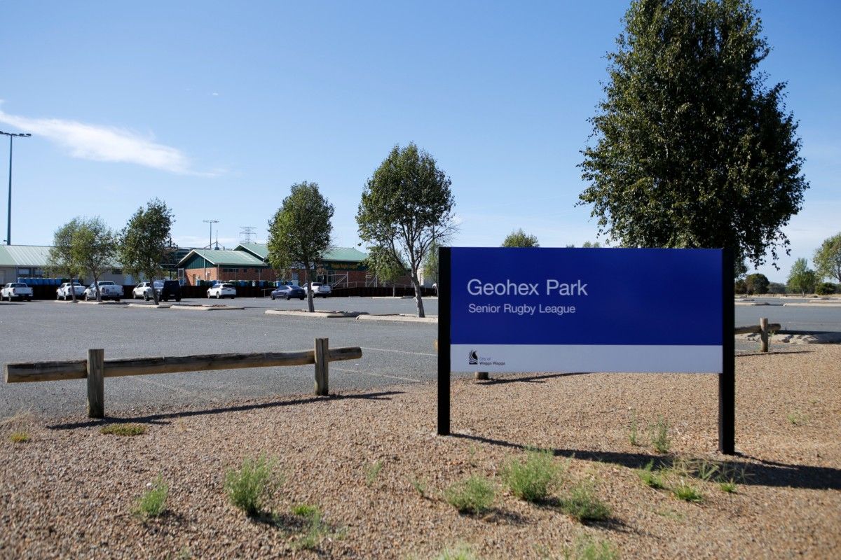 Large blue and white sign saying Geohex Park  Senior Rugby League, with a carpark and sporting facilities in the background.