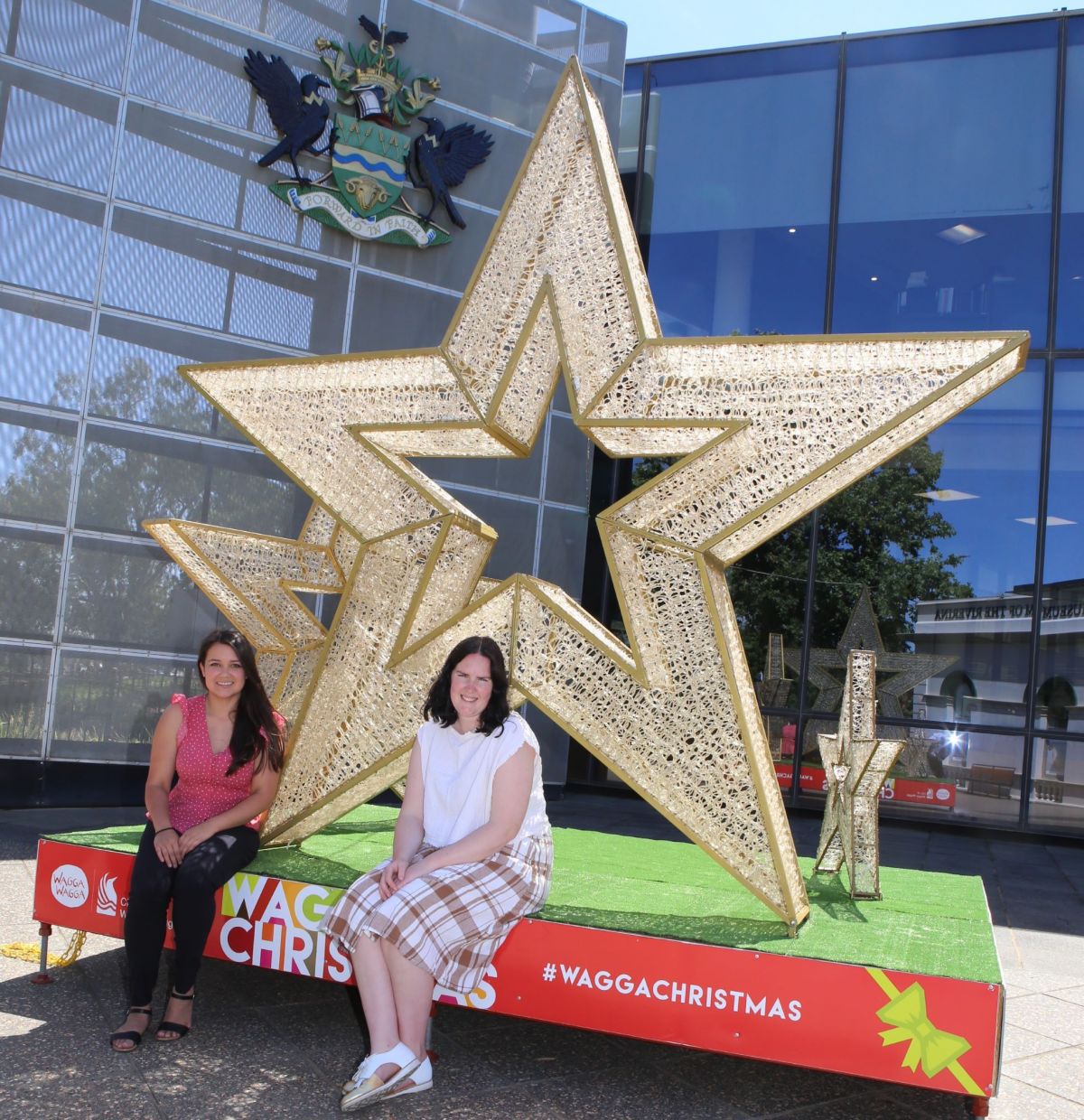 Two women sit in front of a large star