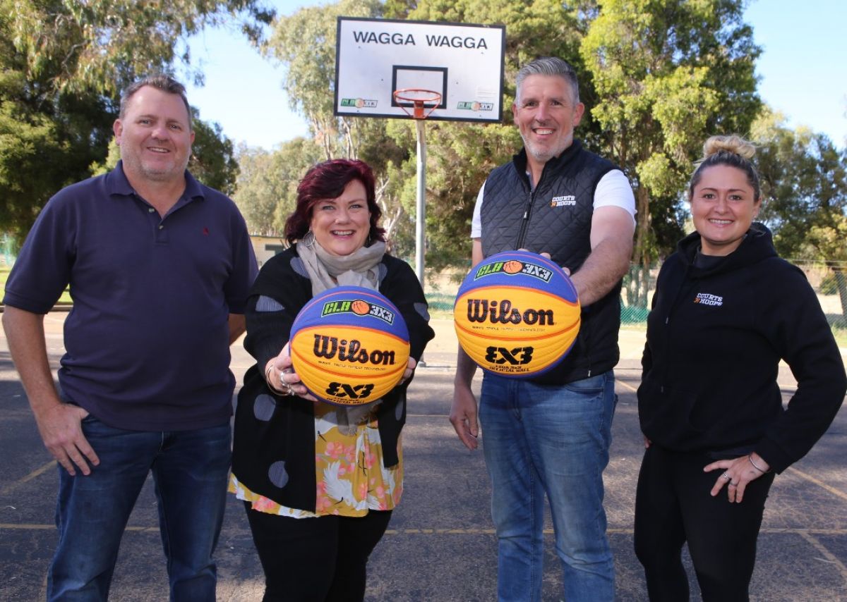 Four people in front of basketball hoop