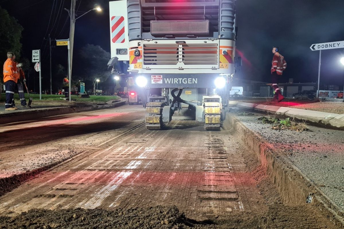 Milling machine milling road surface at night