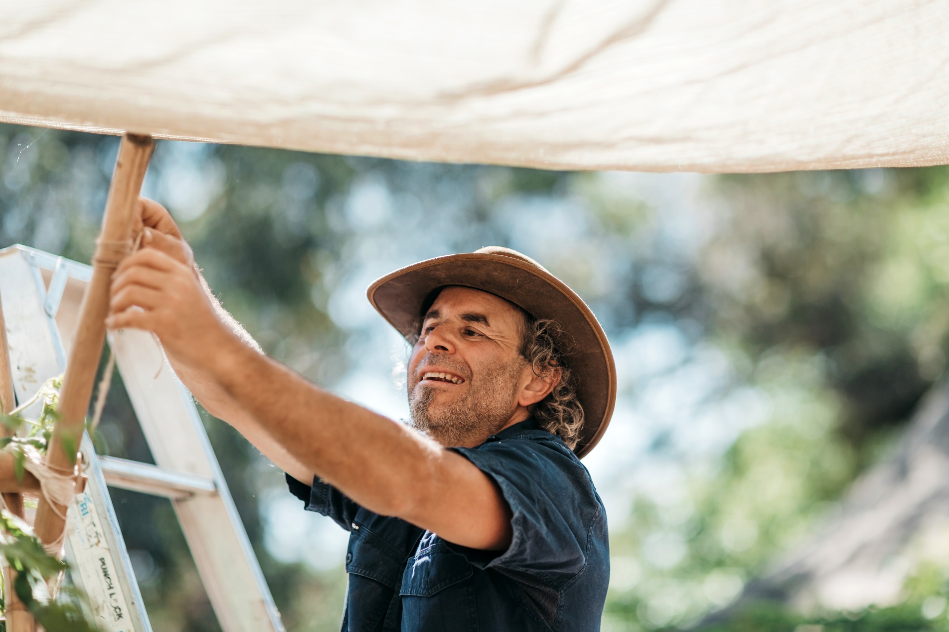 Man putting up shade cloth