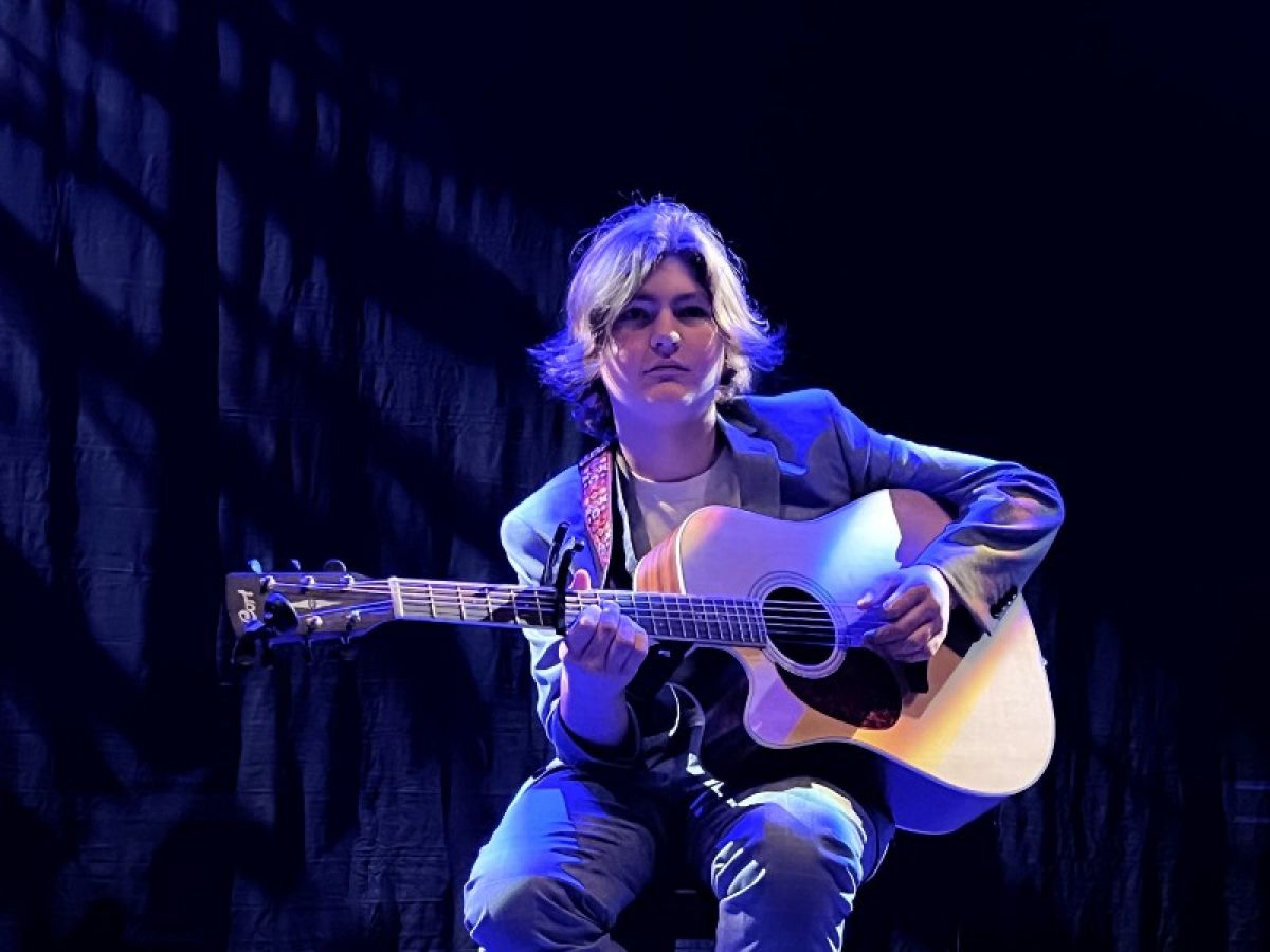 A young man holding a guitar