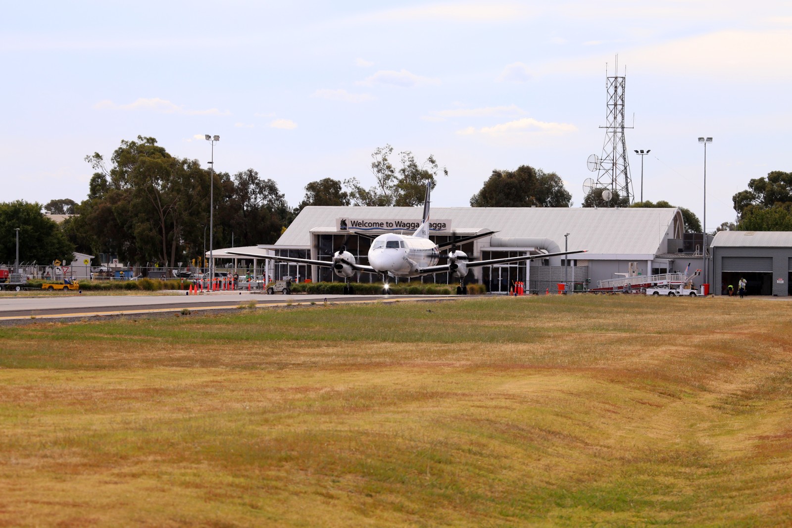 Rex plane taxiing out to runway with Wagga Wagga Airport terminal in background
