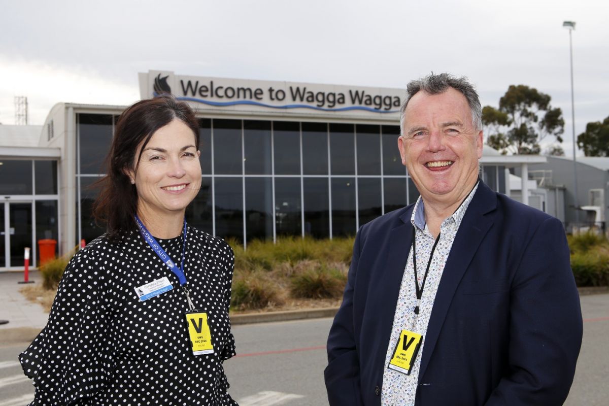 Woman and man standing in front of the Wagga Wagga Airport Terminal