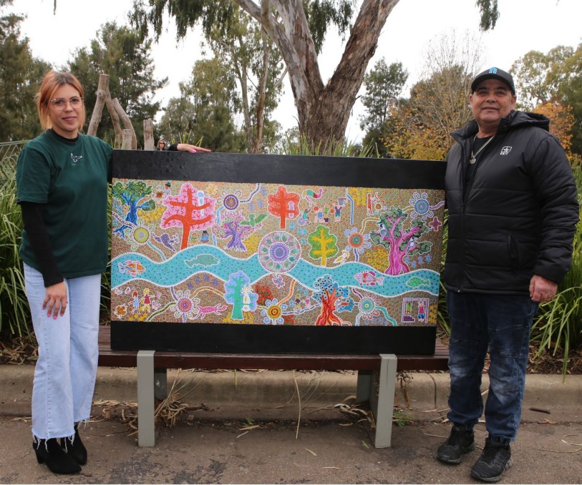 Two people standing with artwork