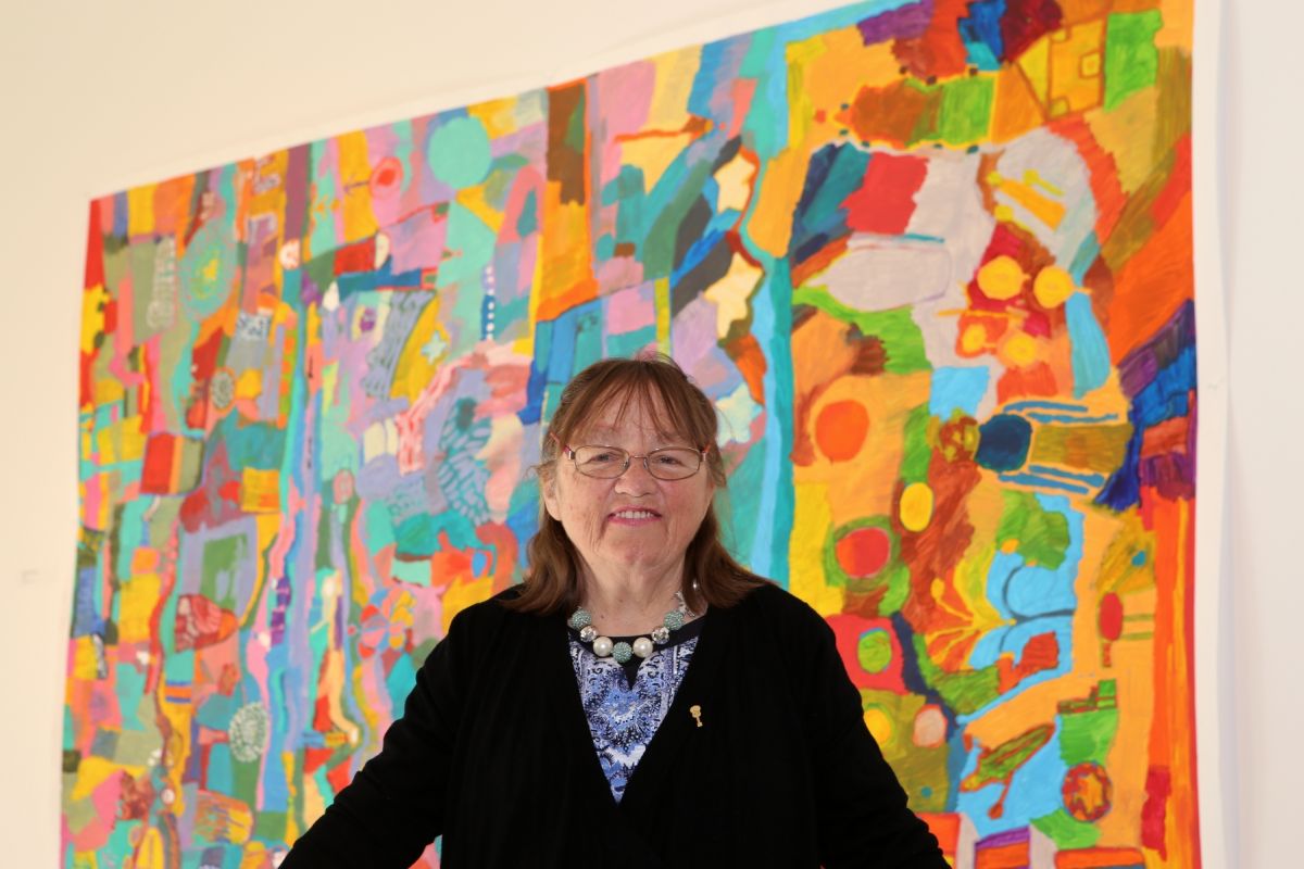 Woman standing in front of colourful painting
