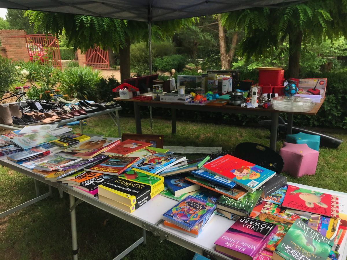 Books, shoes, household items on table in back yard