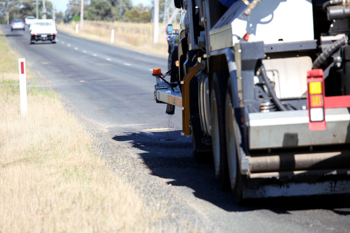 Jet patching track filling potholes on road