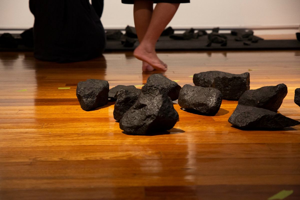 Volcanic rock on timber floor with bare feet in background