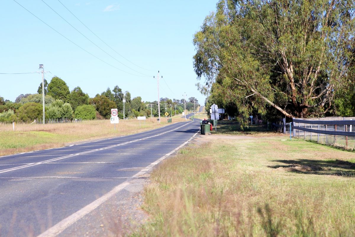 Semi rural road with 80kph sign in foreground