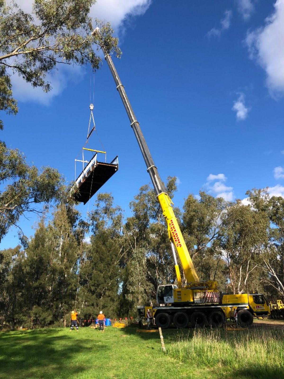 Crane arm lifting footbridge