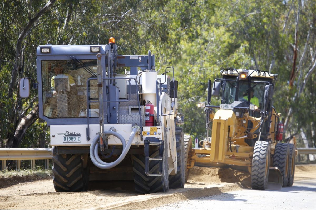 Road grader crews preparing surface of damaged road